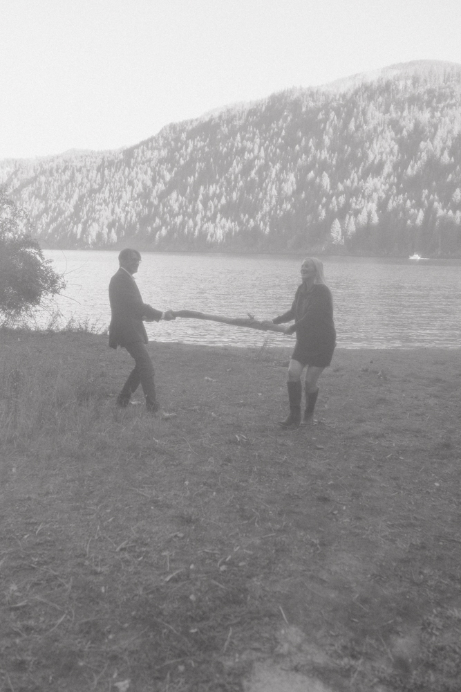 man and woman playing tug of war on the lake shore. 