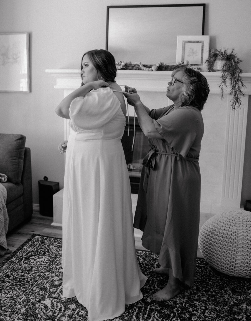 mother of the bride tying her daughter's dress. 