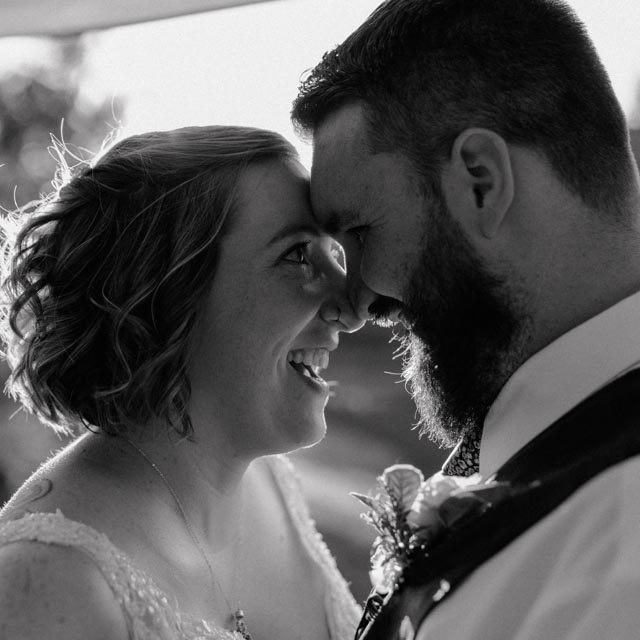 bride and groom touching foreheads as they look at each other and smile.