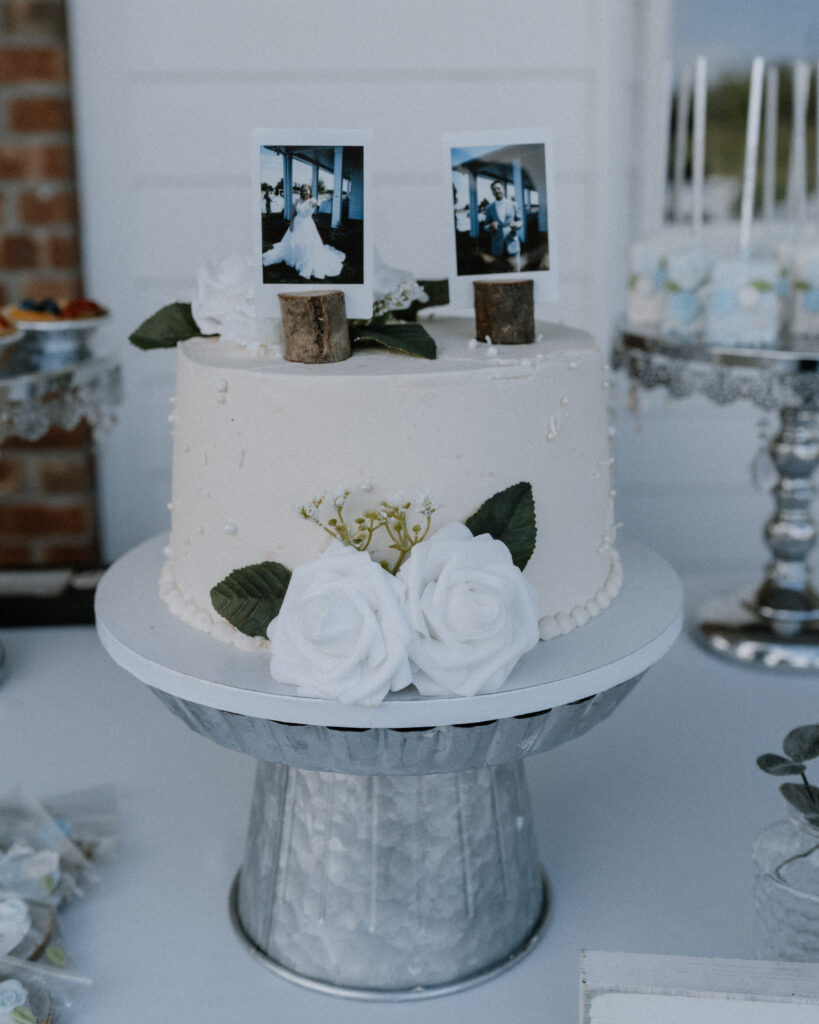 close up of the wedding cake with polaroid photos as the cake topper.