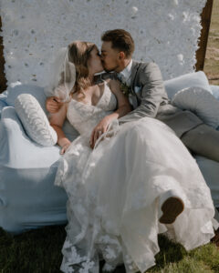 bride and groom sitting and kissing on the comfy couch at their farmhouse wedding in Walla Walla, WA.