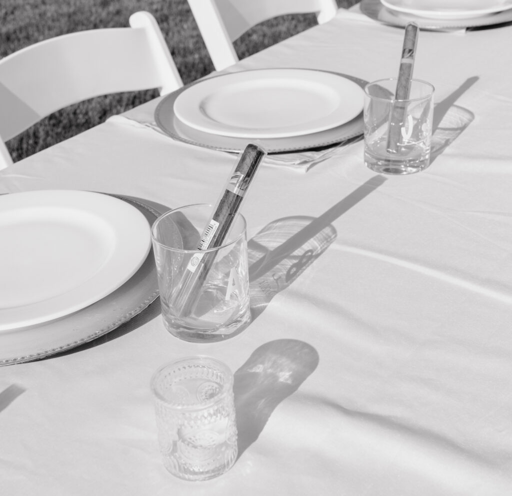 detail of table décor and cigars in the glasses.