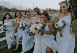 bride and bridesmaids walking and laughing.