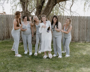 bride and bridesmaid's popping champagne.