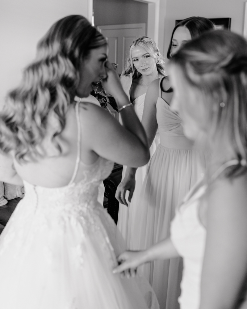 bride crying as she has a moment with her bridesmaids.