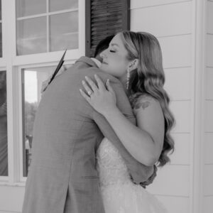 bride smiling as she hugs her groom during the first look on the porch of the Farmhouse wedding in Walla Walla, WA. 