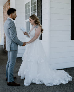 bride and groom holding hands as the bride reads her vows at their farmhouse wedding in Walla Walla, WA.