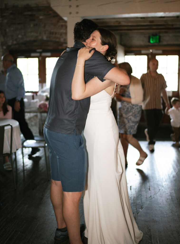 Bride hugging her friend at their intimate wedding photographer. 