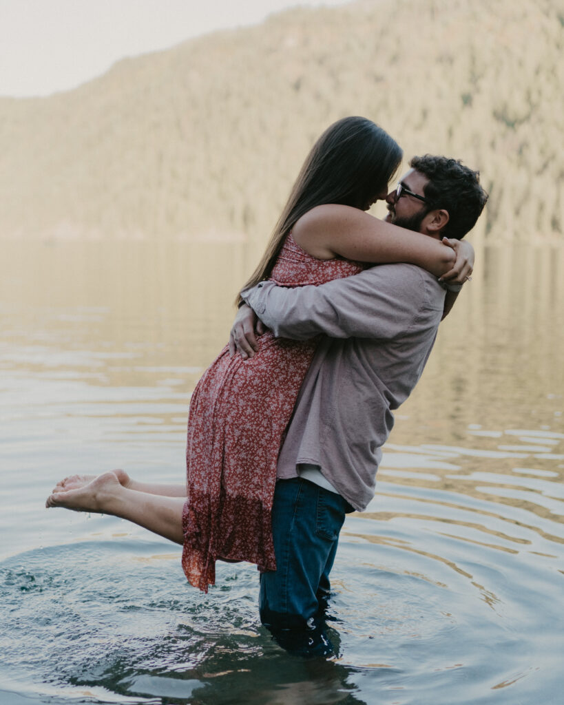 couple embracing at they stand in the water for their Idaho Surprise Proposal.