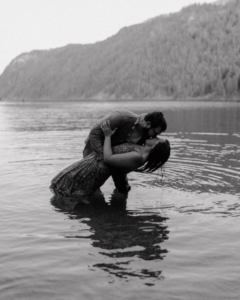 couple kissing in the water as they stand in the Pend Oreille River 