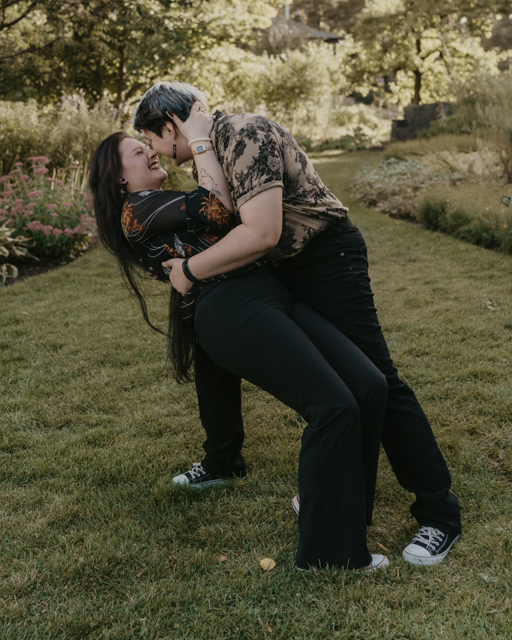 couple doing a dip and kiss in the perennial garden at Manito Park.