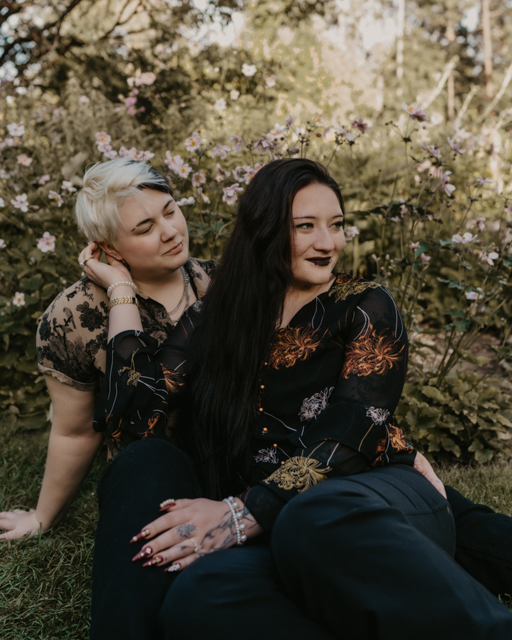 couple sitting on the grass in the Perennial garden at Manito Park 