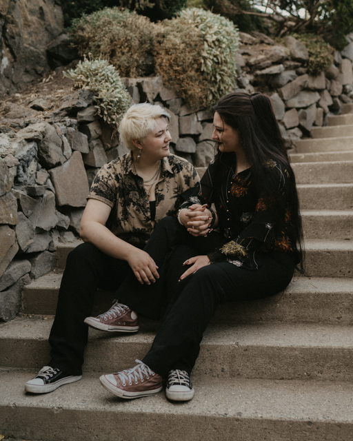 couple sitting on the steps at Manito Park for their engagement session.