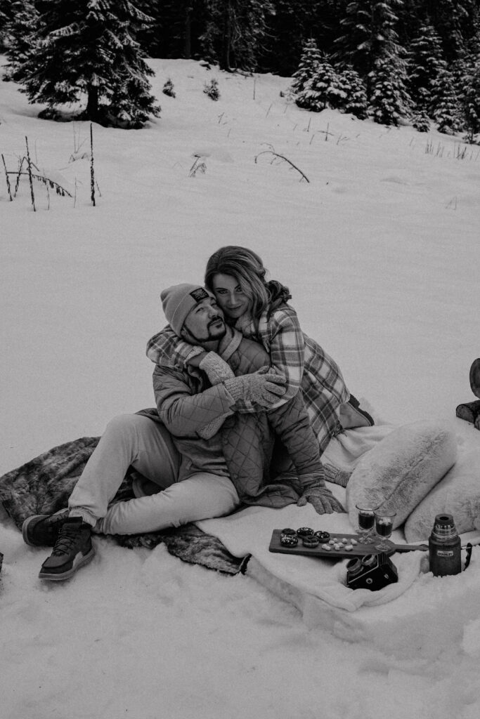 couple sitting on a blanket hugging each other 