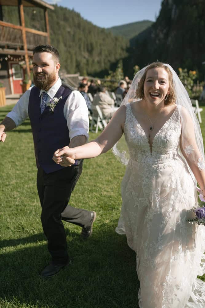 bride and groom happily walking away to their reception after their ceremony.