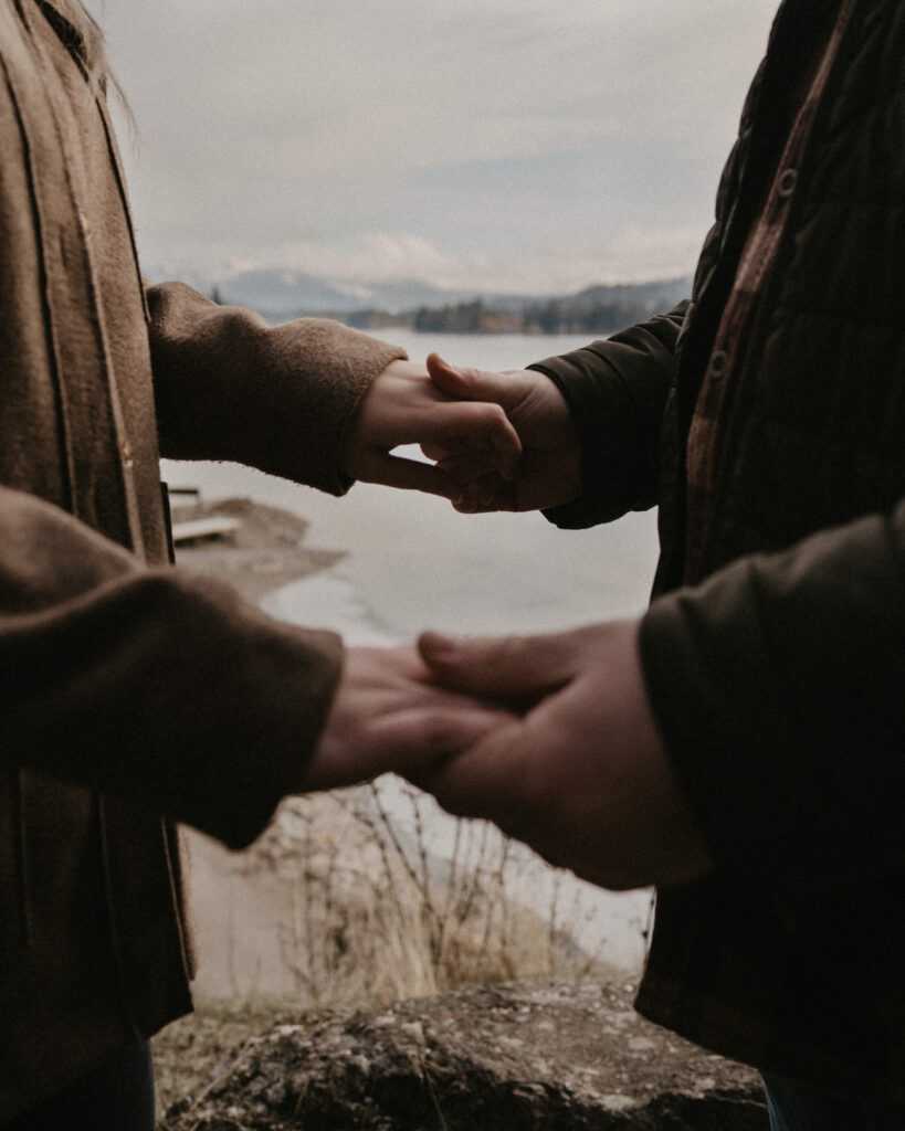 Idaho Winter Couples Session with the couple holding hands with a snow covered mountain backdrop.