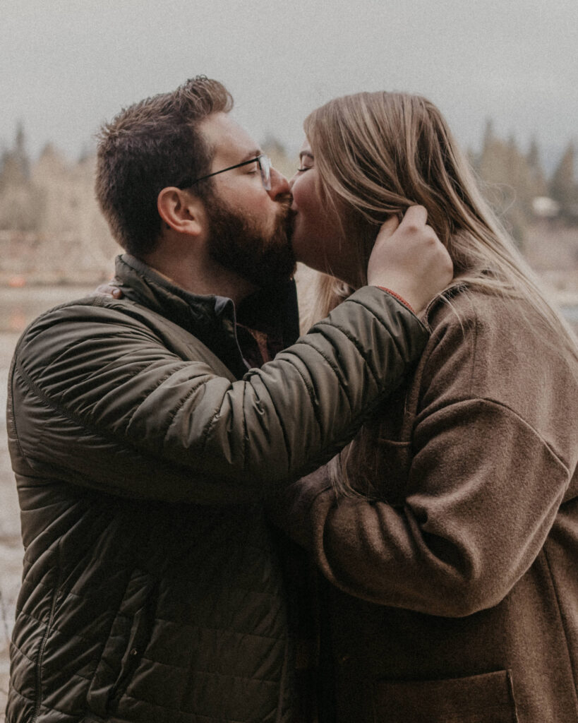 couple kissing as the man pulls back woman's hair. 