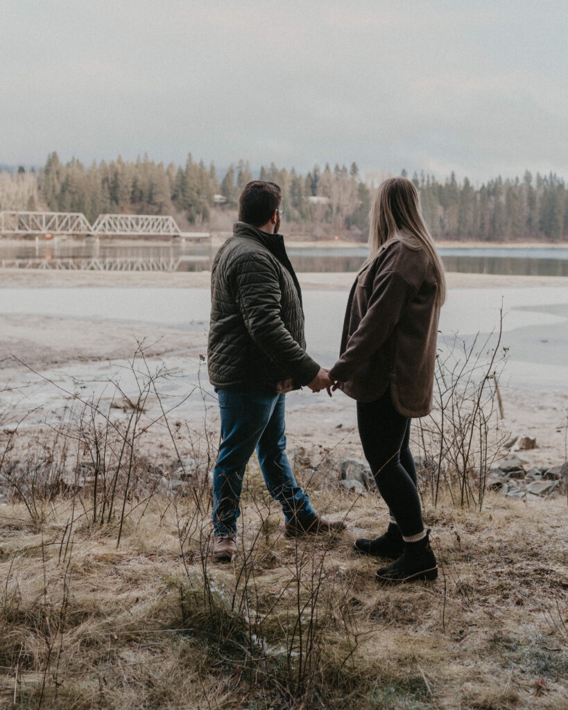 couple looking out at the river and train trestle.