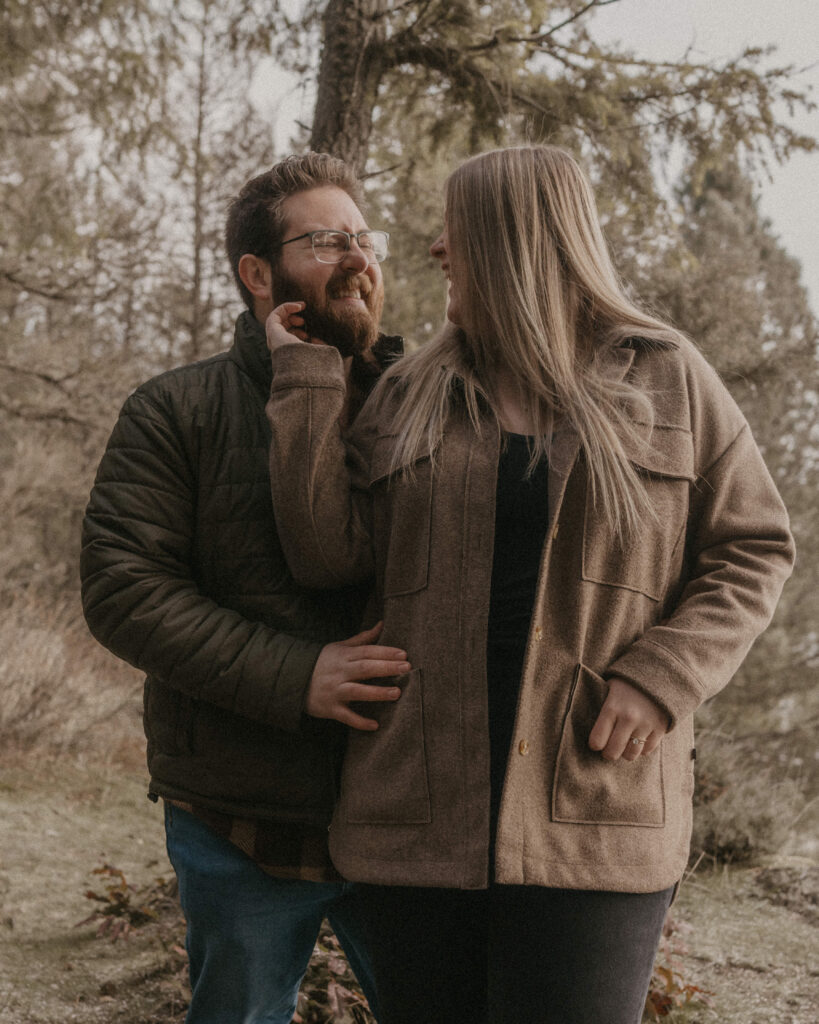 Idaho Winter Couples Session with the couple cozied up and smile at one another.