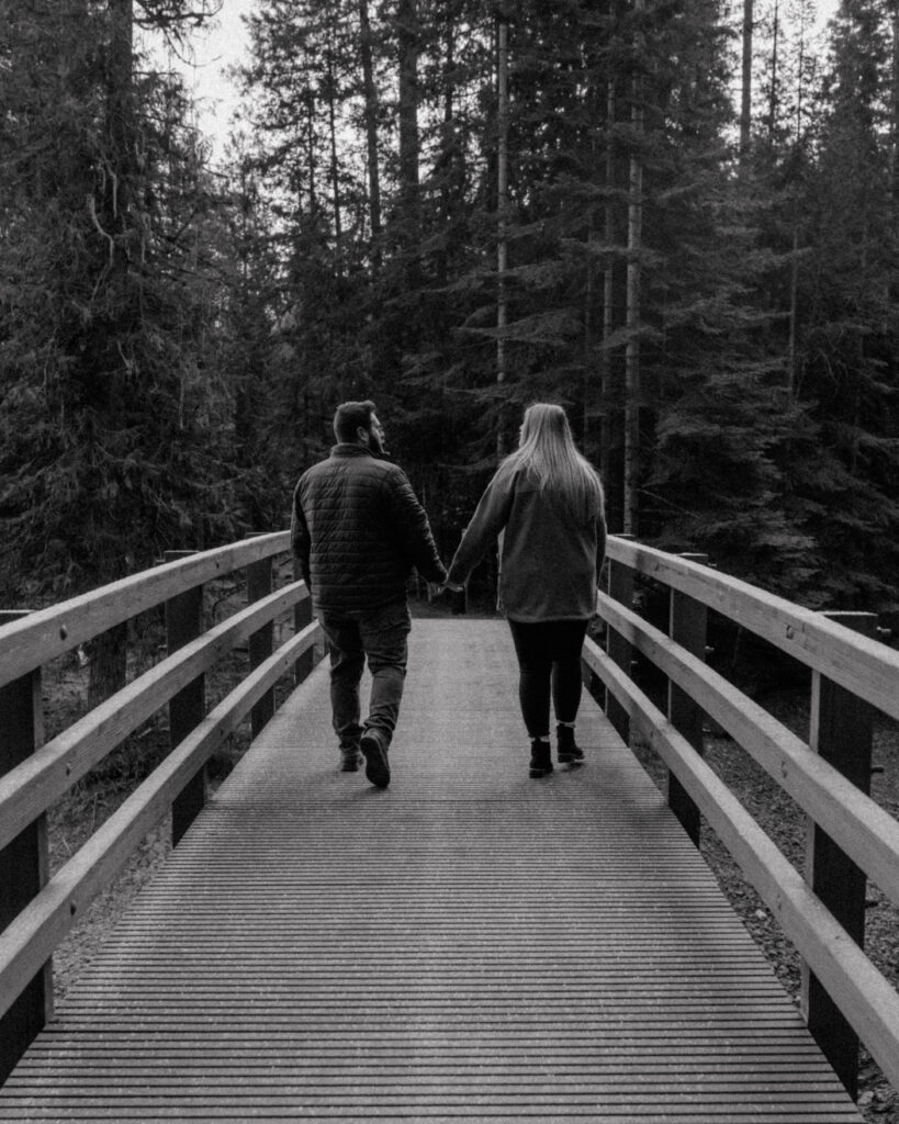 Idaho Winter Couples Session holding hands and looking at each other has they cross the bridge.