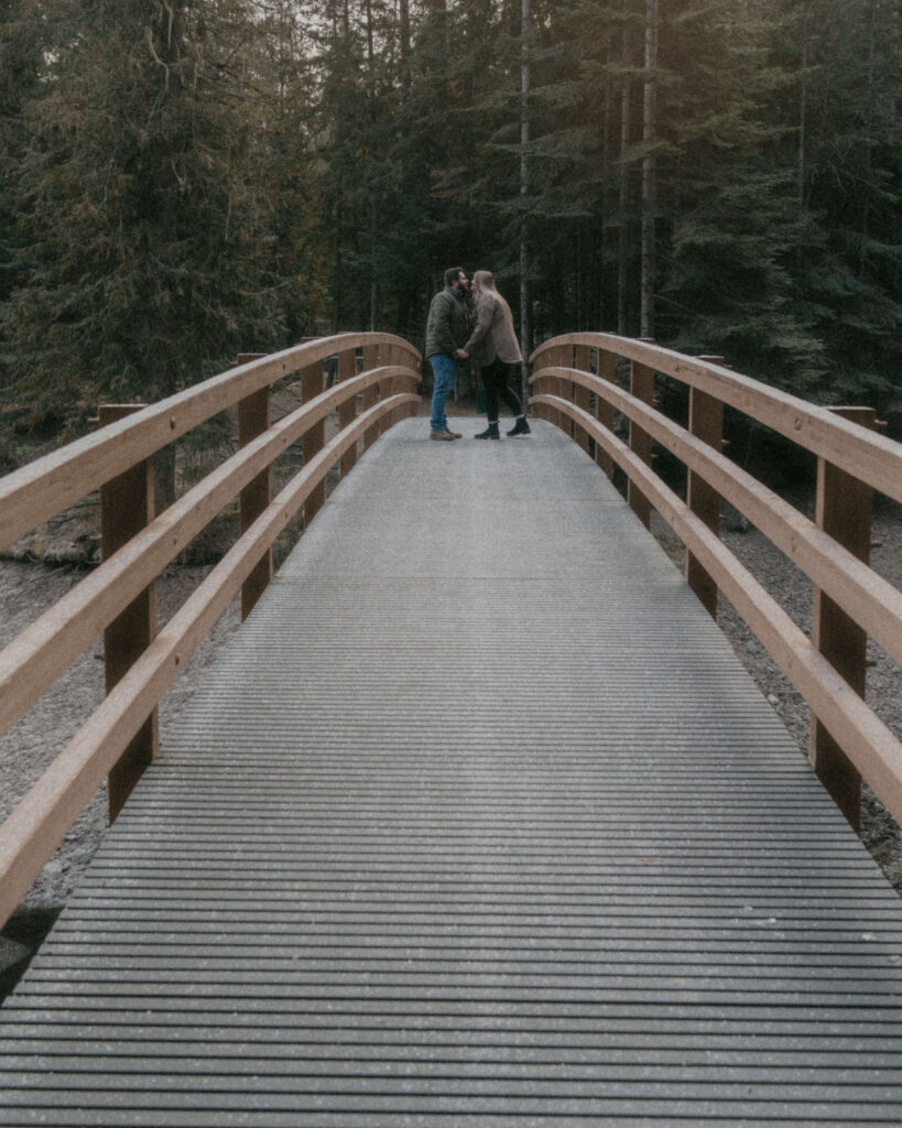 Idaho Winter Couples Session where the couple are kissing in the middle of the bridge.