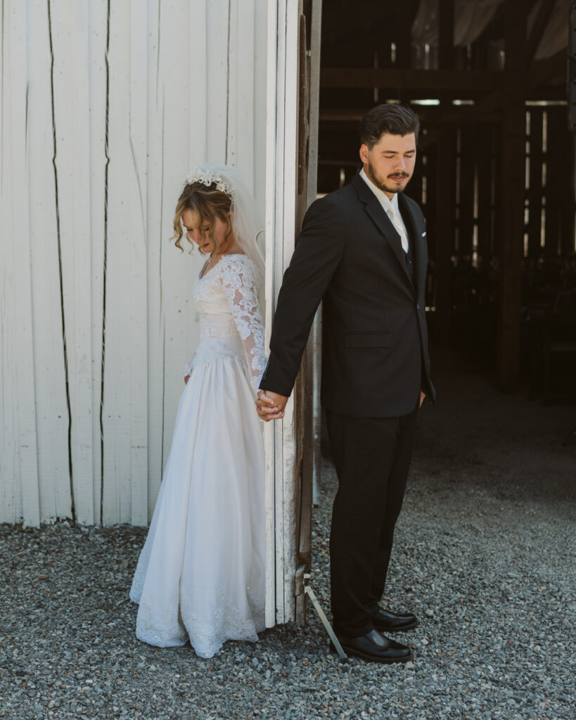 bride and groom holding hands for a first touch before the ceremony begins