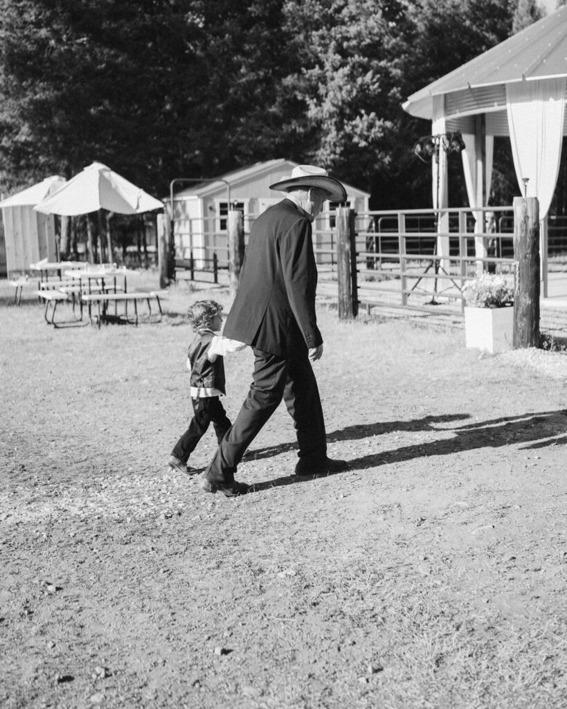bride's grandfather and young boy walking over to the reception space