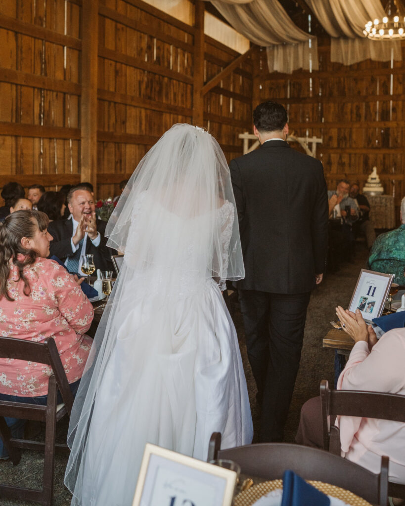 Bride and groom walking in to their reception space before dinner starts