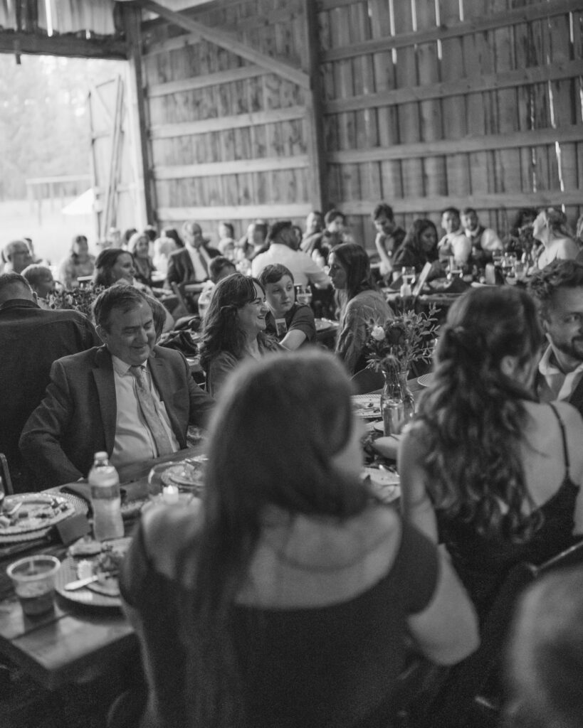 Wedding guests sitting and enjoying their dinner and speeches at Kaniksu Pines Farm in North Idaho