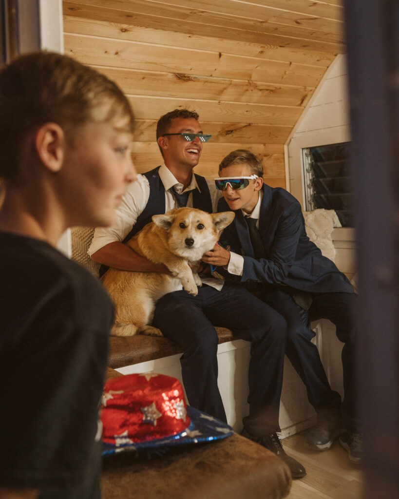 wedding guests and the venue owner's dog taking photos in the Coeur d' Alene Photo Bus in North Idaho 